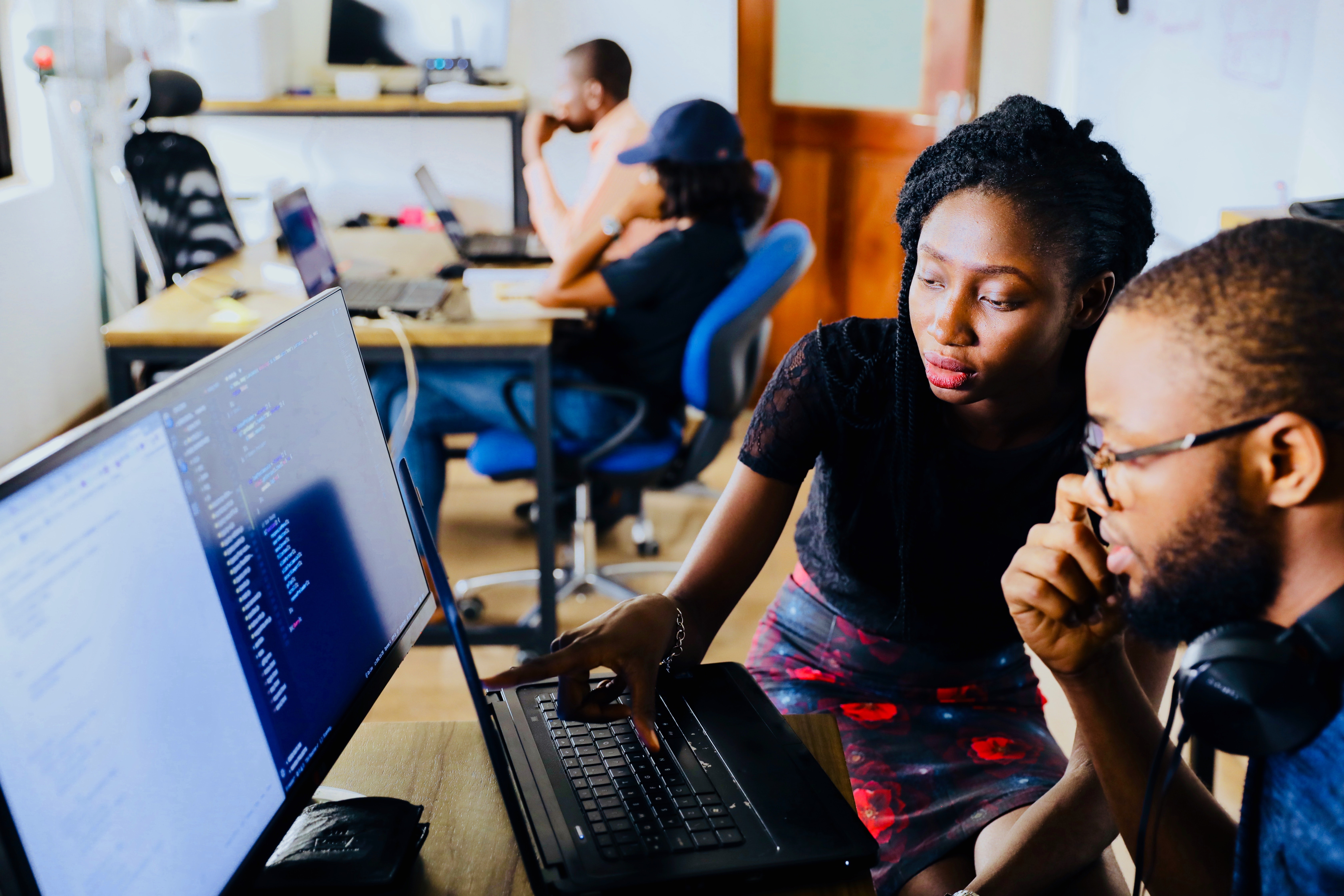 A woman showing a man something on a computer screen